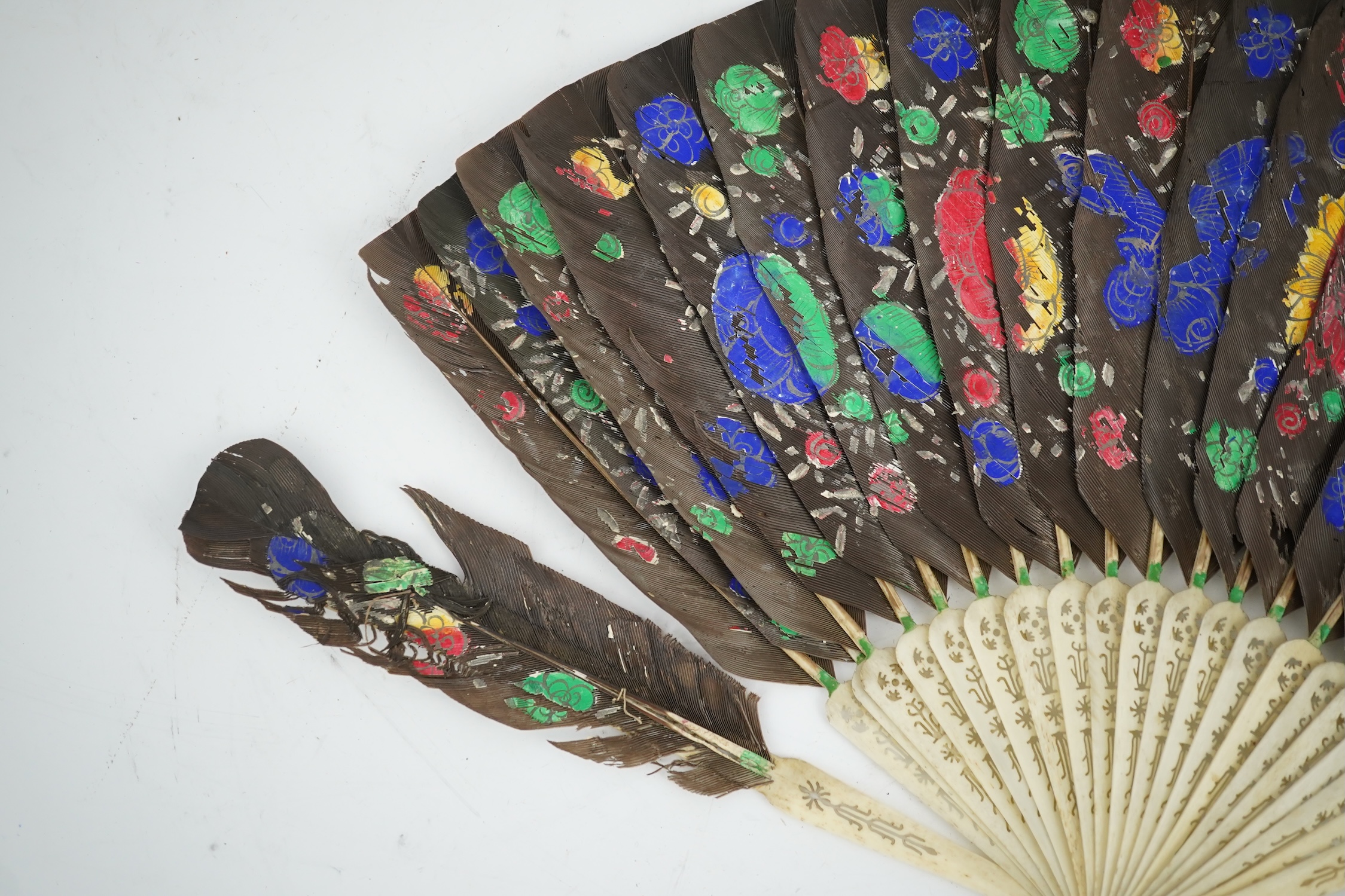 Three 19th century Chinese feather fans: One a carved bone brise black feather fan together with two similar carved sandalwood feather fans, two fans have hand painted decoration on the feathers both sides, the pink feat